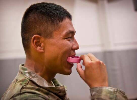 A Tactical Air Control Party candidate inserts a mouth guard before combative skills training at the Aderholt Fitness Center on Hurlburt Field, Fla., Sept. 17, 2013. The candidates went through a five-day combative training course as a part of their technical training. (U.S. Air Force photo/Senior Airman Krystal M. Garrett) 