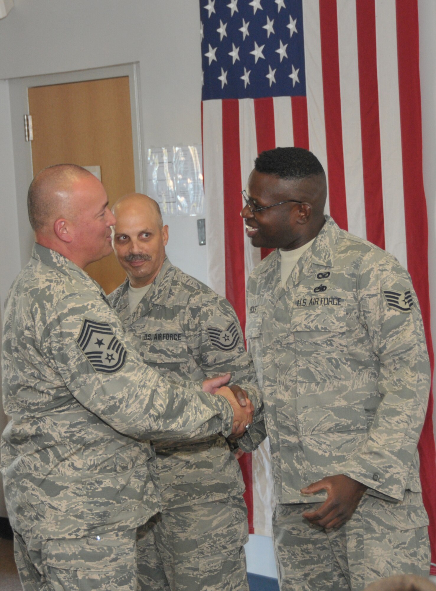 SCOTIA, N.Y. -- Chief Master Sgt. Mitchell Brush, Senior Enlisted Adviser for the National Guard Bureau, presents Tech. Sgt. Keith Eriole (left), 109th Force Support Squadron, and Staff Sgt. David Ricks, 109th Maintenance Group, with a chief's coin in recognition for their assistance to the 109th's chief's council.  (Air National Guard photo by Master Sgt. William M. Gizara/Released)