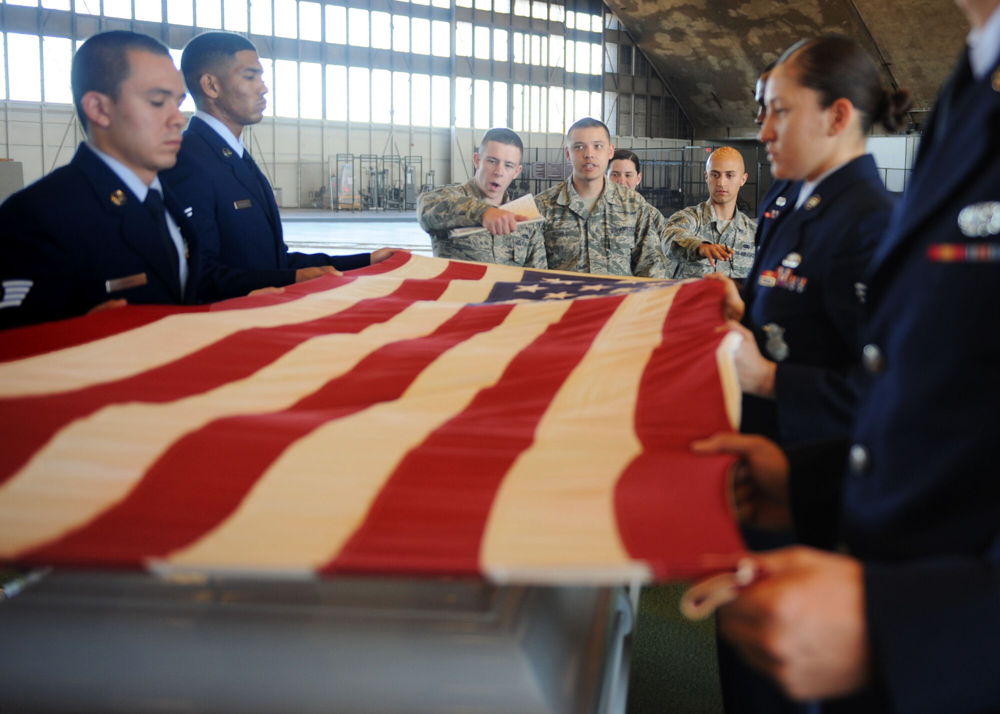 Senior Airmen Troy Billard (left), Christopher Bovill, 28th Maintenance Squadron Non-Destructive Inspection laboratory technicians, and Bradley Sutter, 28th Logistics Readiness Squadron fuels distribution technician, evaluate Airmen during the final inspection of an honor guard training course in the Pride Hangar at Ellsworth Air Force Base, S.D. Sept. 19, 2013. During the inspection, trainees are evaluated on a wide range of aspects including dress and appearance and military bearing. (U.S. Air Force photo by Airman 1st Class Rebecca Imwalle/Released)