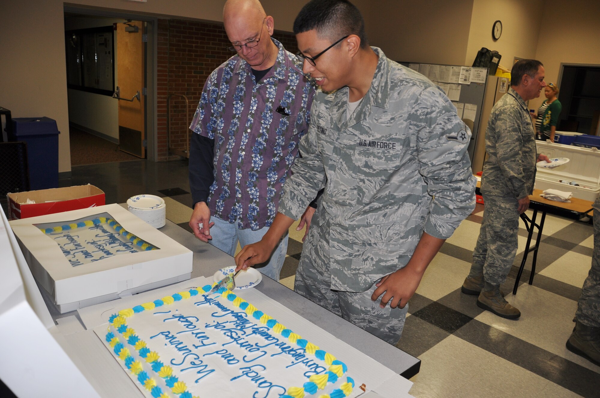 Airman Christian Zetino, 514th Operations Group member and youngest Airman in attendance, follows tradition in slicing the first piece of cake at the Hot Diggity Dog Day held here Sept. 26. Freedom wing members were treated to a complimentary lunch to celebrate wing accomplishments and withstanding tough financial and personal challenges during the course of the year (U.S. Air Force photo/Senior Airman Chelsea Smith).