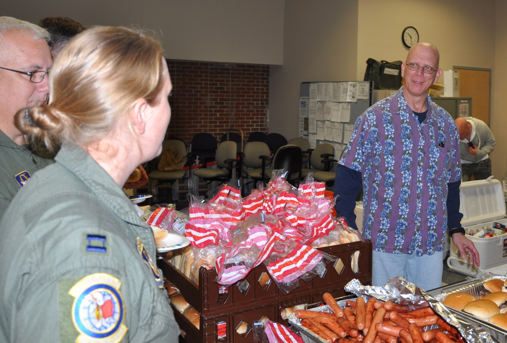 Col. Michael Underkofler, 514th Air Mobility Wing commander, welcomes attendees of the Hot Diggity Dog Day as they proceed through the queue for a complimentary barbeque lunch here Sept. 26. Underkofler greeted attendees and monitored food levels during the two-hour event celebrating wing accomplishments and the end of a successful fiscal year (U.S. Air Force photo/Senior Airman Chelsea Smith).