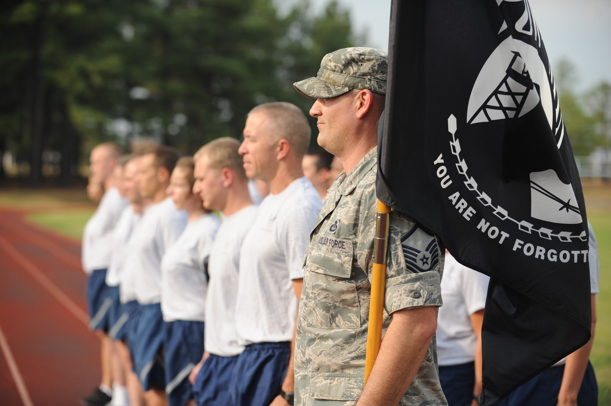 Members of the 19th Medical Group stand at attention during retreat before the Prisoner of War/Missing in Action Recogniton run Sept. 19, 2013, at Little Rock Air Force Base, Ark. Team Little Rock Airmen carried the POW/MIA flag during the 24-hour run. (U.S. Air Force photo by Airman 1st Class Cliffton Dolezal)