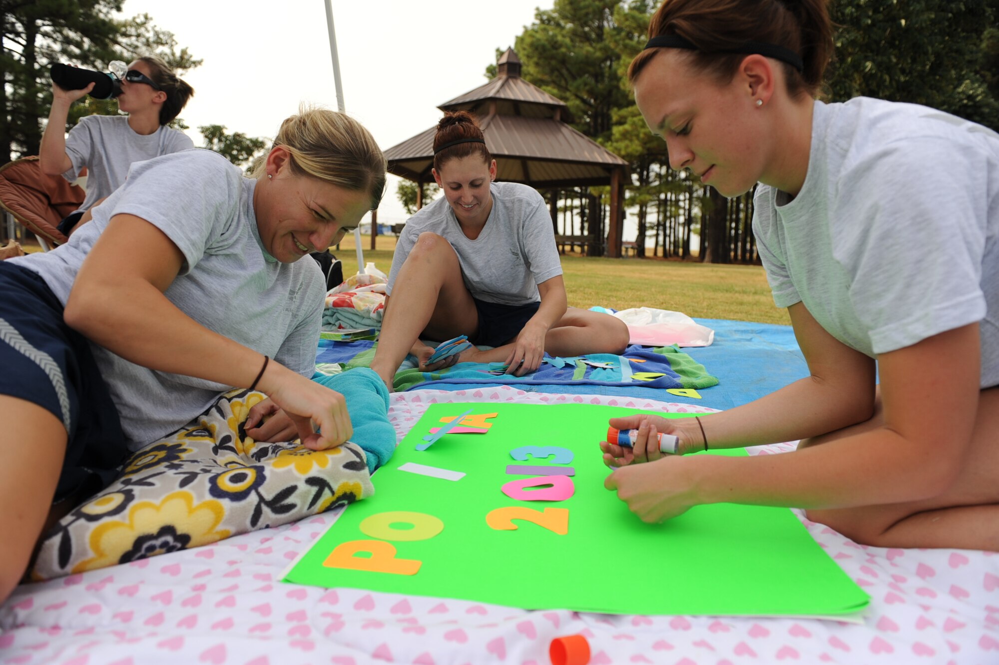Staff sergeants (from left) Brylie Reeves, Shanna Wilkerson, Jennifer Baer and Danielle Hauch from the 19th Aerospace Medicine Squadron assemble a poster to tally the total miles run by their five-person team  Sept. 19, 2013, at Little Rock Air Force Base, Ark. The group completed the 24-hour run with 136.5 miles combined. (U.S. Air Force photo by Airman 1st Class Cliffton Dolezal)