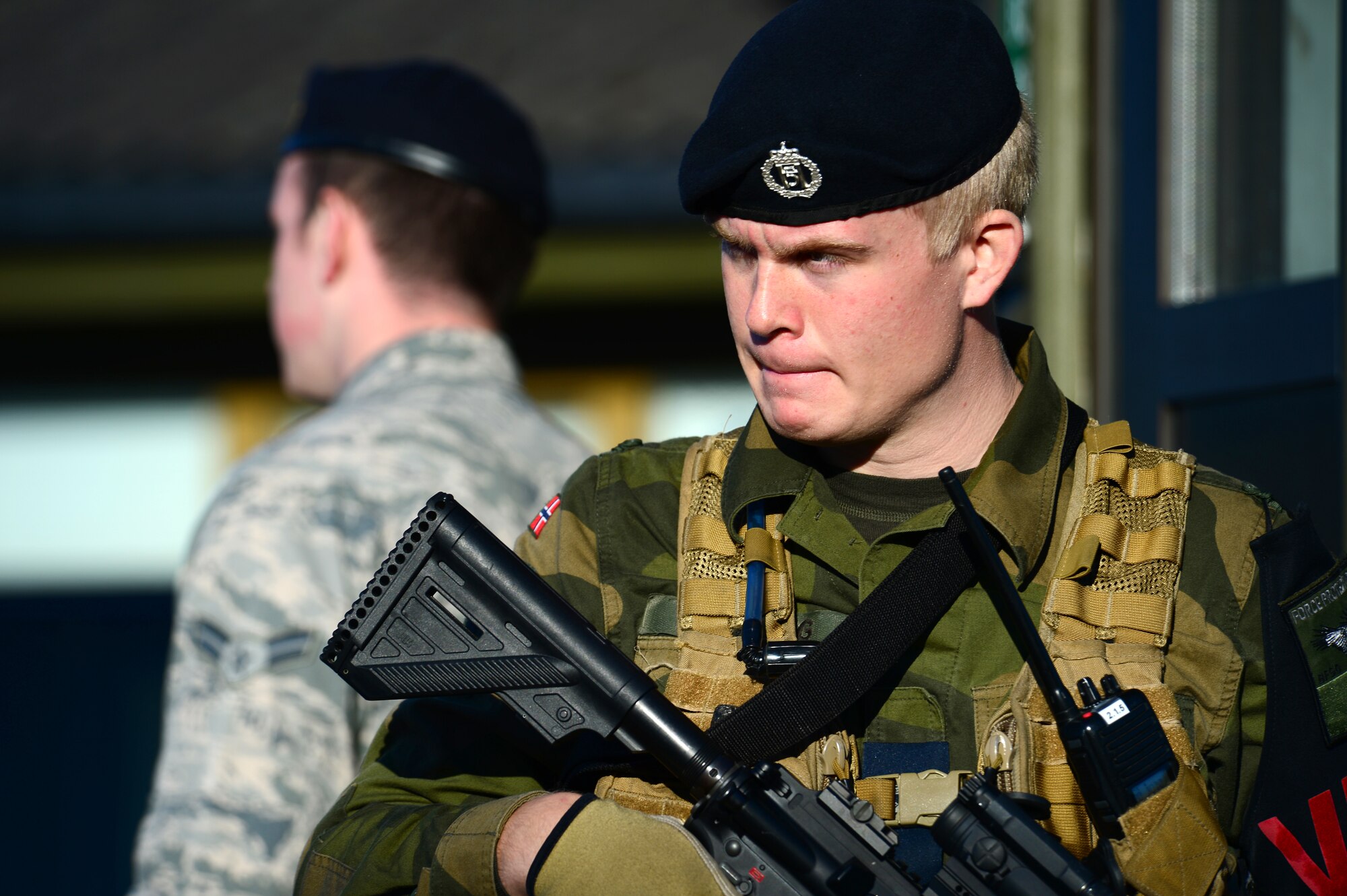 Royal Norwegian Air Force Pvt. Henrik Krefting stands guard with Airman 1st Class Brandon Elliott, 48th Security Forces Squadron response force team member, at Bodø Main Air Station, Norway, Sept. 25, 2013. Members from the 48th SFS worked along with their host nation counterparts to assist with installation security during the Arctic Challenge Exercise 2013. ACE-13 was a combined exercise with NATO and regional allies, which promoted continued interoperability between the United States, Norway, Sweden, Finland, United Kingdom and NATO. (U.S. Air Force photo by Master Sgt. Lee Osberry/Released)