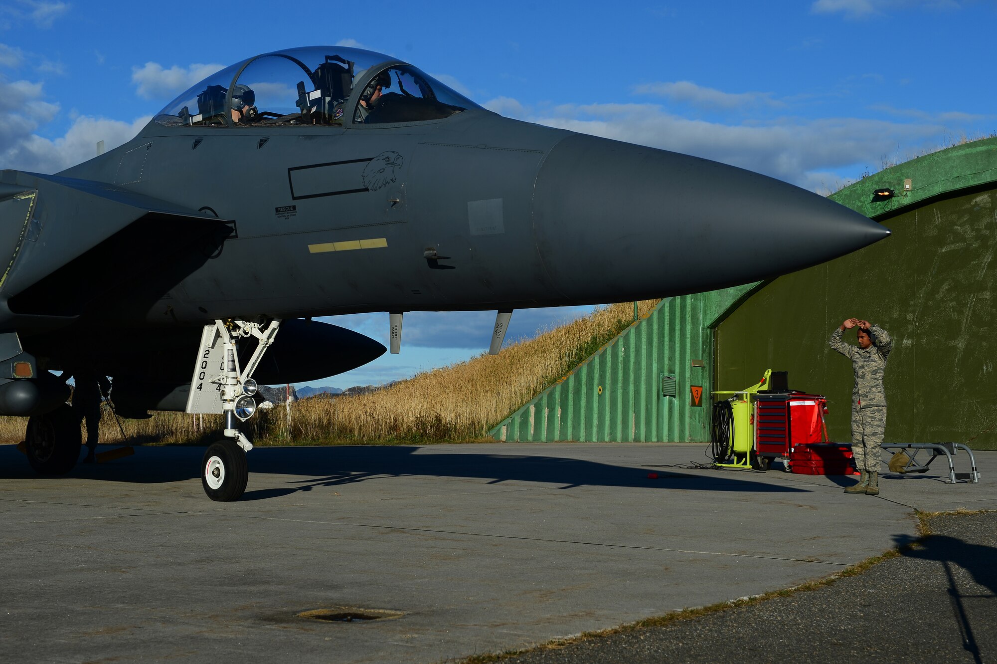 Airman Joseph Ruggiero, 494th Aircraft Maintenance Unit crew chief, marshalls an F-15E Strike Eagle at Bodø Main Air Station, Norway, Sept. 24, 2013. Ruggiero is amongst approximately 600 personnel deployed from multiple bases within U.S. Air Forces in Europe-Air Forces Africa, supporting the Arctic Challenge Exercise 2013. ACE-13 was a combined exercise with NATO and regional allies, which promoted continued interoperability between the United States, Norway, Sweden, Finland, United Kingdom and NATO. (U.S. Air Force photo by Master Sgt. Lee Osberry/Released)