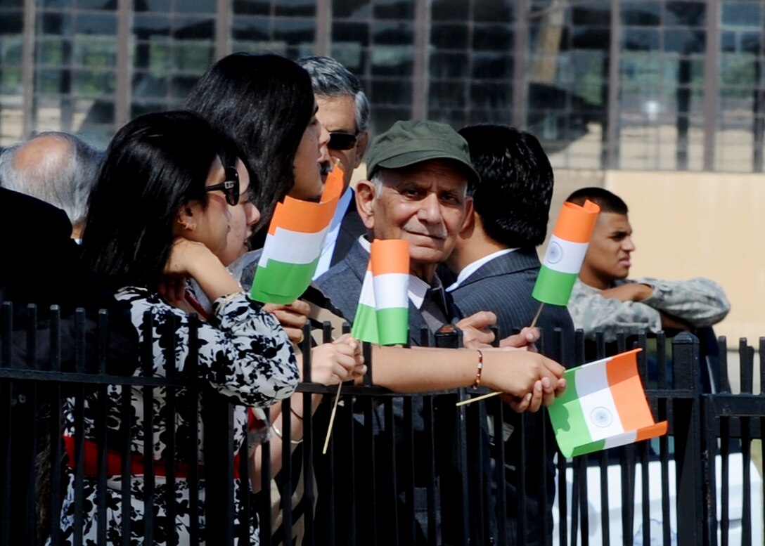 People line the fence and wave the flag of India to welcome Prime Minister of India Dr. Manmohan Singh as he arrives to Joint Base Andrews, Md., Sept. 26, 2013. The Prime Minister arrived for a two-day visit to meet with President Barack Obama and First Lady Michelle Obama. The Prime Minister was accompanied by his wife Gursharan Kaur and was welcomed by U.S. State Department?s Acting Deputy Chief of Protocol Rosemarie Pauli. (U.S. Air Force photo/Staff Sgt. Nichelle Anderson)