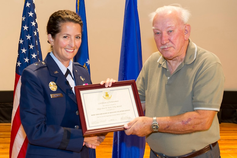 Brig. Gen. Nina Armagno, 45th Space Wing commander, presents retired Master Sgt. Peter Koch, Project Emeritus office volunteer, with a certificate of achievement for volunteering more than 4,000 hours, during a commander’s call. Koch maintains Project Emeritus’ accounting system volunteer hours, monitors and uploads lists of area retirees for phone recruiting and is designated as the primary contact in the wing voting office. (U.S. Air Force photo/Cory Long)