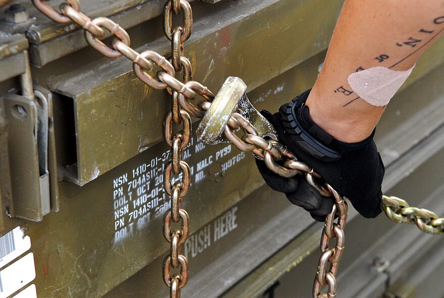 A U.S. Air Force 18th Munitions Squadron Tactical Ammunition Rapid Response Package crew member handles chains to secure munitions during a TARRP exercise on Kadena Air Base, Japan, Sept. 25, 2013. The TARRP exercise simulates how the squadron would respond in times of war as the Airmen handle live missiles for a simulated mission. (U.S. Air Force photo by Staff Sgt. Lauren Snyder)