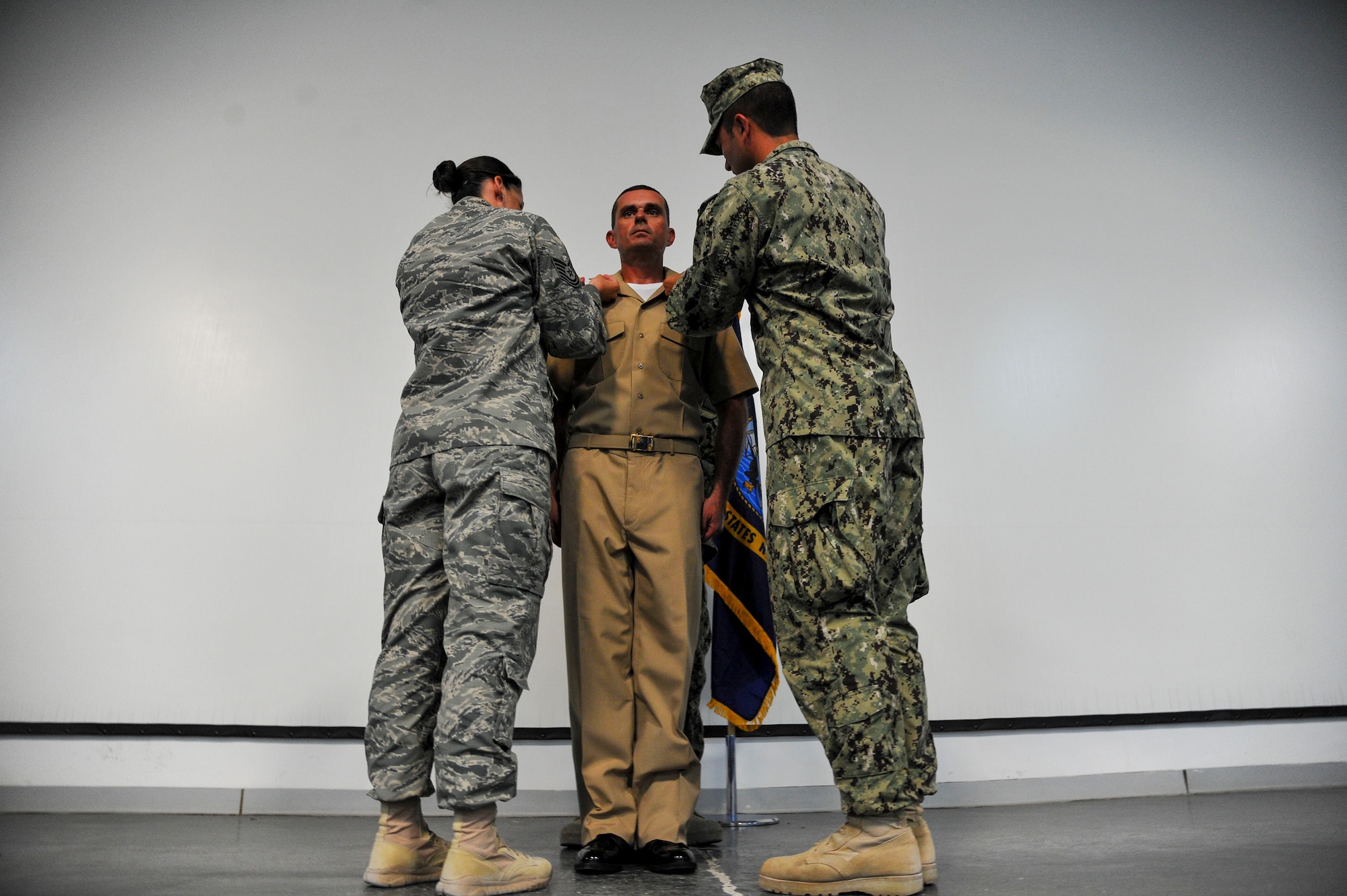 Chief Petty Officer Michael DeMartin is pinned by his sponsors during a chief petty officer ceremony at the 379th Air Expeditionary Wing in Southwest Asia, Sept. 21, 2013. Rich in traditions and rituals, which guide much of Navy life, the chief petty officer pinning ceremony is preserved to ensure Sailors stay consistent with the Navy’s core values of honor, courage and commitment.  DeMartin’s hometown is Detroit, Mi., and assigned to NAS Sigonella 0192.  (U.S. Air Force photo/Tech. Sgt. Joselito Aribuabo) 