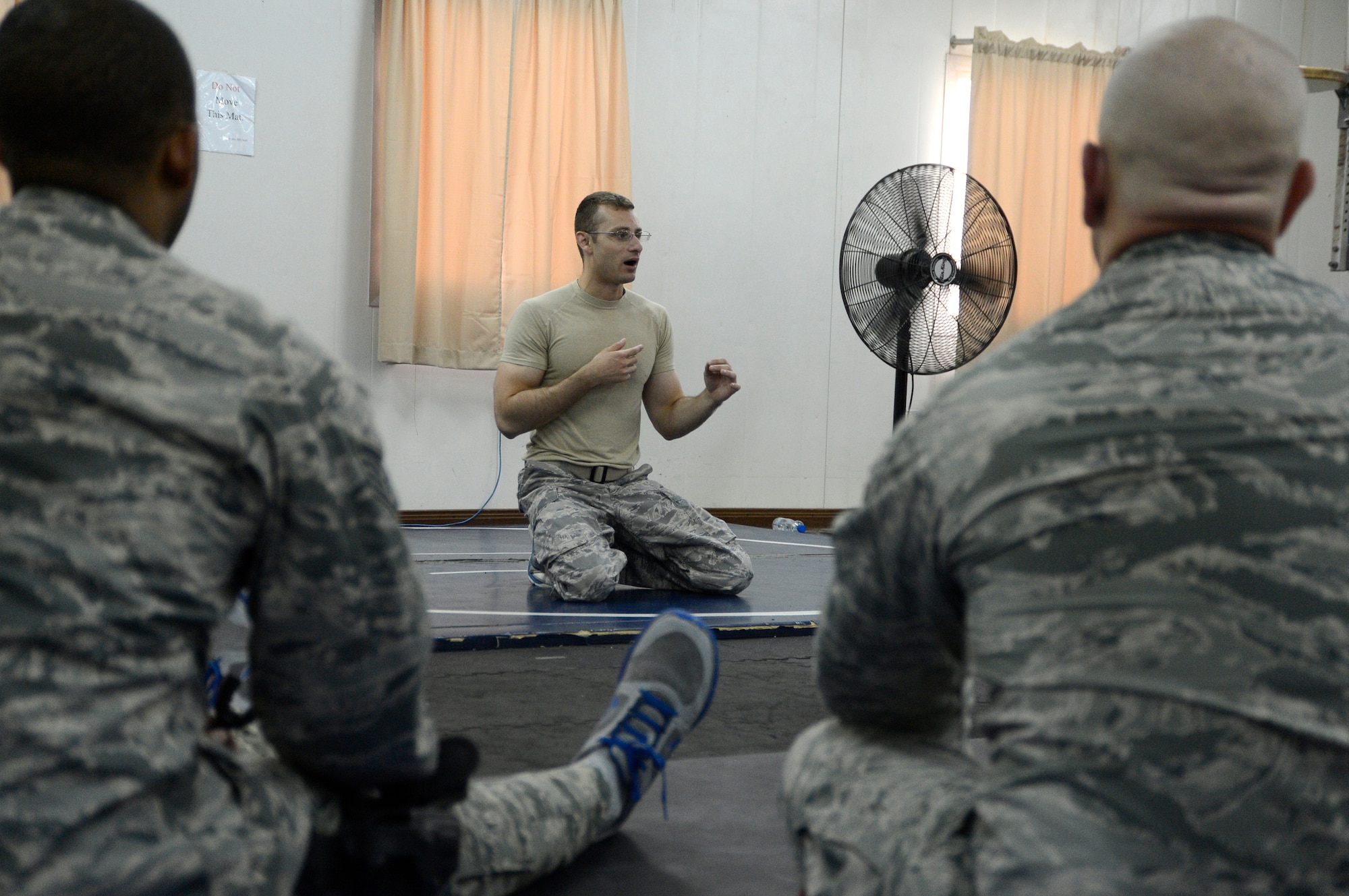 Staff Sgt. Trevor Creighton, 386th Air Expeditionary Wing, check six facilitator, talks to students during a combatives class here, Sept. 19, 2013.  Creighton impresses upon the class the importance of staying vigilant during the instruction portion so they can link techniques and moves together at the final stage of the exercise. Creighton is deployed out of the 366th Security Forces Squadron, Mountain Home AFB, Idaho, and is a native of Naples, Fla.    (U.S. Air Force photo by Master Sgt. Christopher A. Campbell)