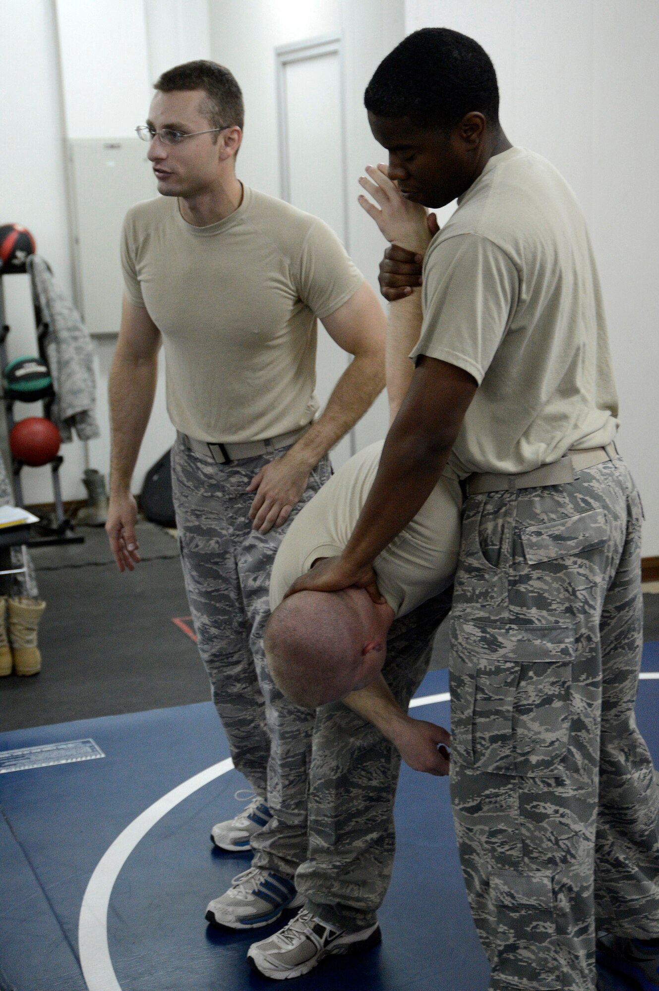 (From front to back) Tech. Sgt. Antroine Lovett and Staff Sgt. Matthew Edwards demonstrate the neutral tie up method while Staff Sgt. Trevor Creighton explains the move to the students during a combatives class here, Sept. 19, 2013.  Each move is first shown to the students by the trainers before moving into the practical phase.  Lovett, Edwards and Creighton, 386th Air Expeditionary Wing check six facilitators, offer this class to members base wide.  Lovett is deployed out of the 802nd Security Forces Squadron, Lackland Air Force Base, San Antonio, Texas, and is a native of Monroe, La.  Edwards is deployed out of the 325th Security Forces Squadron, Tyndall AFB, Fla. and is a native of Fayette, Ala.  Creighton is deployed out of the 366th Security Forces Squadron, Mountain Home AFB, Idaho, and is a native of Naples, Fla.    (U.S. Air Force photo by Master Sgt. Christopher A. Campbell)