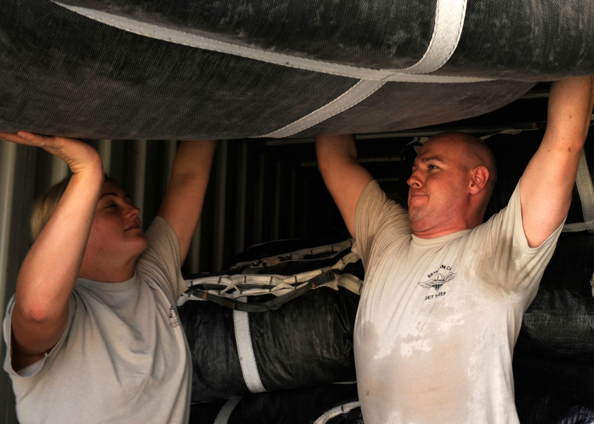 U.S. Army Spcs. Molly Burrows and Jefferson Thomas stack parachutes into a container at the 379th Air Expeditionary Wing in Southwest Asia, Sept. 23, 2013. Both are 861st Quartermaster Company Detachment 1 airdrop specialist deployed from William F. Lyell Armed Forces Reserve Center, Tenn. Burrows hails from Eagleville, Tenn., and Thomas is Hendersonville, Tenn., native. (U.S. Air Force photo/Senior Airman Bahja J. Jones) 

