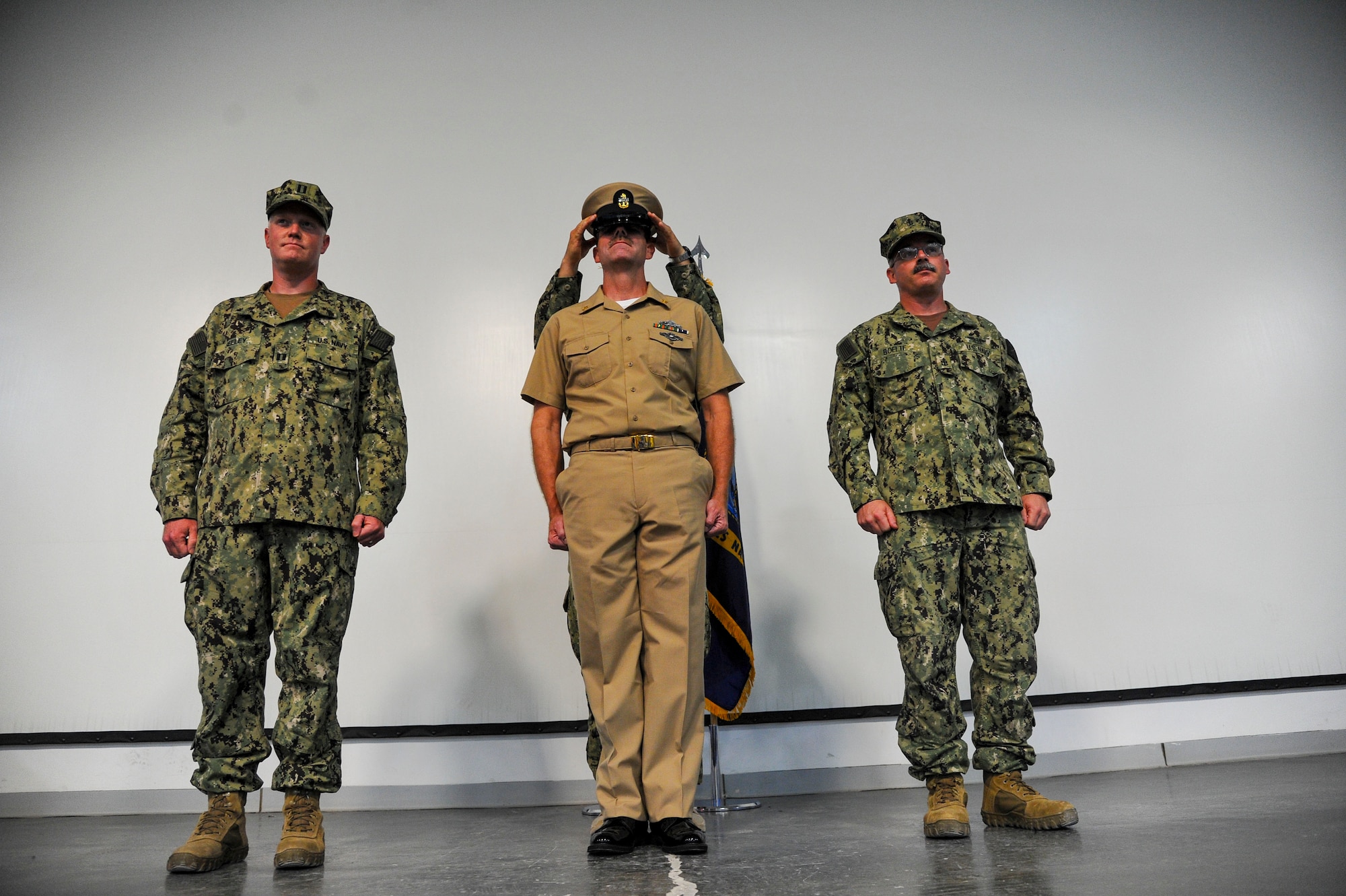 Chief Petty Officer Timothy Spicer is presented his chief petty officer combination cover during a pinning ceremony at the 379th Air Expeditionary Wing in Southwest Asia, Sept. 21, 2013. Rich in traditions and rituals, which guide much of Navy life, the chief petty officer pinning ceremony is preserved to ensure Sailors stay consistent with the Navy’s core values of honor, courage and commitment. Spicer is a logistic specialist assigned to the Expeditionary Warfare-Fleet Marine Forces, hails from Rogers, Mn., and assigned to Navy Air Cargo Handling Battalion 7, Great Lakes, Il. (U.S. Air Force photo/Tech. Sgt. Joselito Aribuabo)