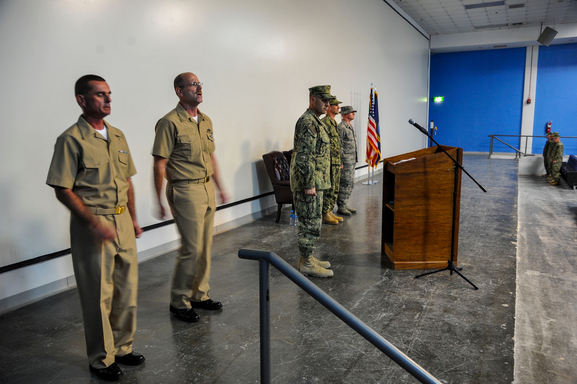 New U.S. Navy Chief Petty Officers, Timothy Spicer and Michael DeMartin, sing “Anchors Away” during the chief petty officer pinning ceremony at the 379th Air Expeditionary Wing in Southwest Asia, Sept. 21, 2013. Rich in traditions and rituals, which guide much of Navy life, the chief petty officer pinning ceremony is preserved to ensure Sailors stay consistent with the Navy’s core values of honor, courage and commitment. Spicer is deployed from Navy Air Cargo Handling Battalion 7, Great Lakes, Il., hails from Rogers, Mn., and DeMartin’s hometown  is Detroit, Mi., assigned to NAS Sigonella 0192, both are logistic specialists. (U.S. Air Force photo/Tech. Sgt. Joselito Aribuabo)