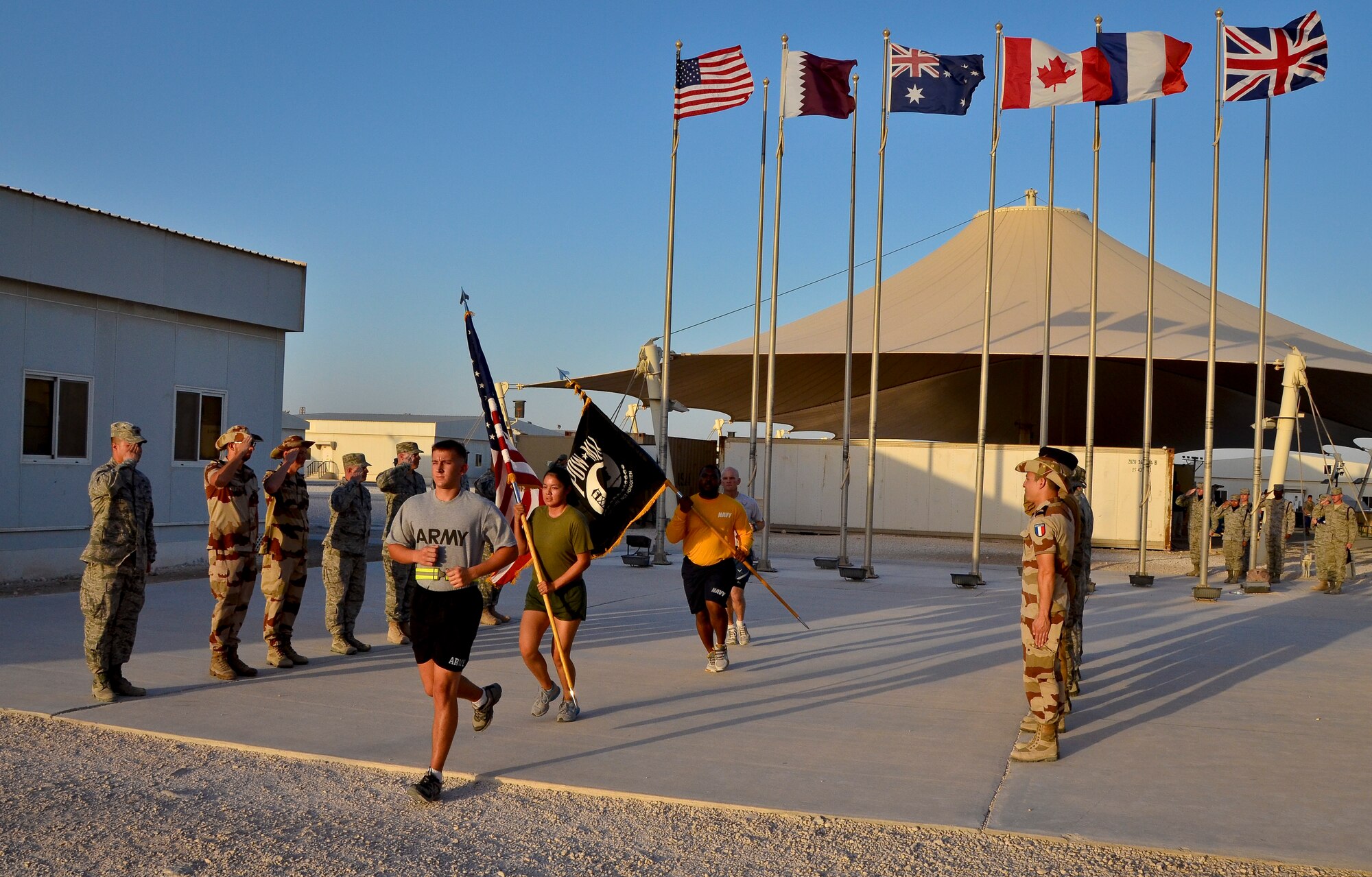 Service members from the U.S. Army, Marine Corps, Navy and Air Force complete the 24-hour prisoners of war and missing in action vigil run as U.S. military, coalition and mission partners render salutes at the 379th Air Expeditionary Wing in Southwest Asia, Sept. 21, 2013. The run began Sept. 20 and culminated with a closing ceremony and traditional flag folding by the base honor guard in reverence to those still missing. (U.S. Air Force photo/Staff Sgt. Benjamin W. Stratton)