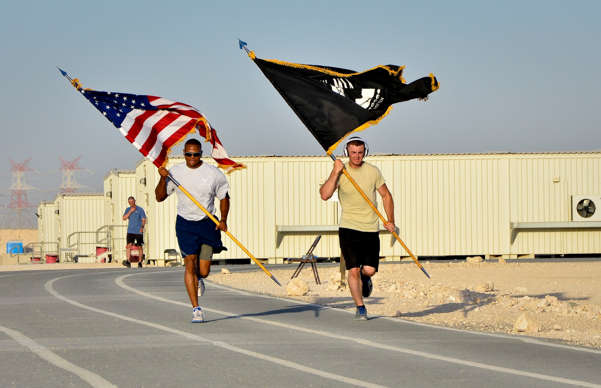 Service members deployed to the 379th Air Expeditionary Wing participate in the 24-hour prisoners of war and missing in action vigil run at the 379th AEW in Southwest Asia, Sept. 21, 2013. The run began Sept. 20 and culminated with a closing ceremony and traditional flag folding by the base honor guard in reverence to those still missing. (U.S. Air Force photo/Staff Sgt. Benjamin W. Stratton)
