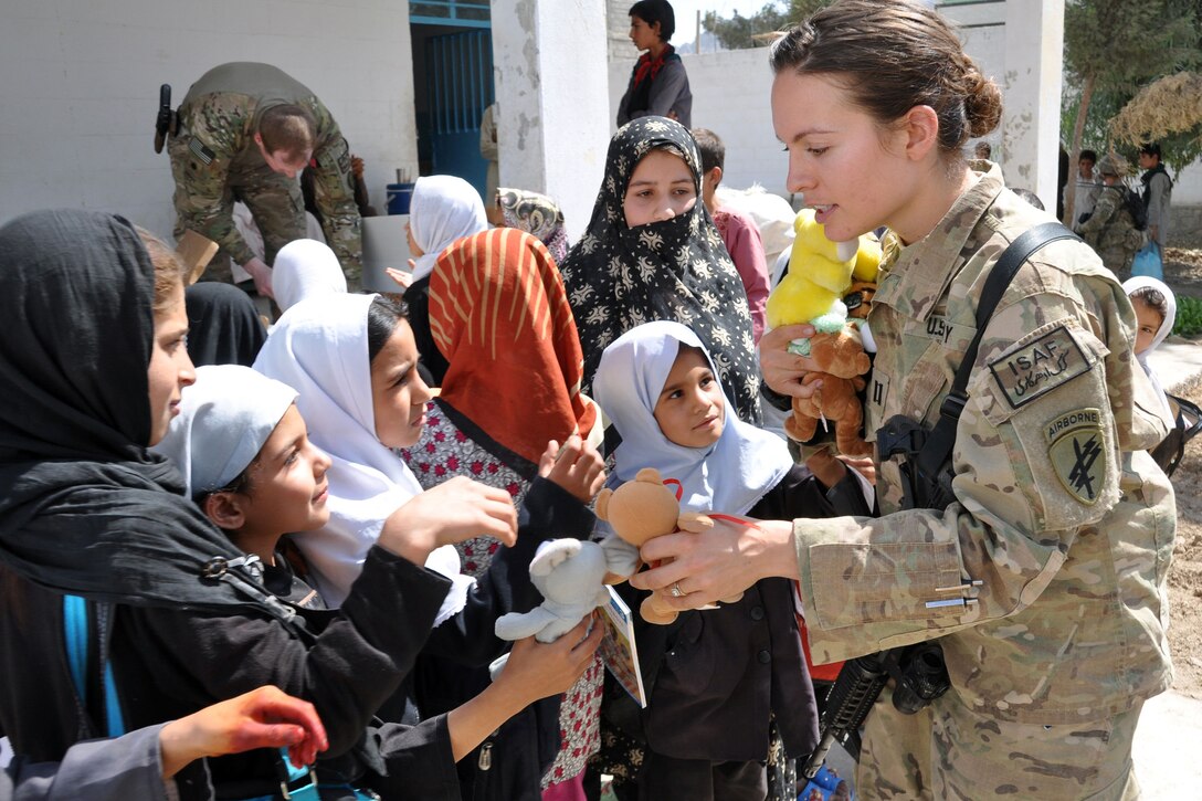 U.S. Army Capt. Jennifer Leathers gives donated stuffed animals to Afghan orphans during a visit to deliver toys, books and health supplies to children at the Farah Orphanage in Farah City, Afghanistan, Sept. 266, 2013. 