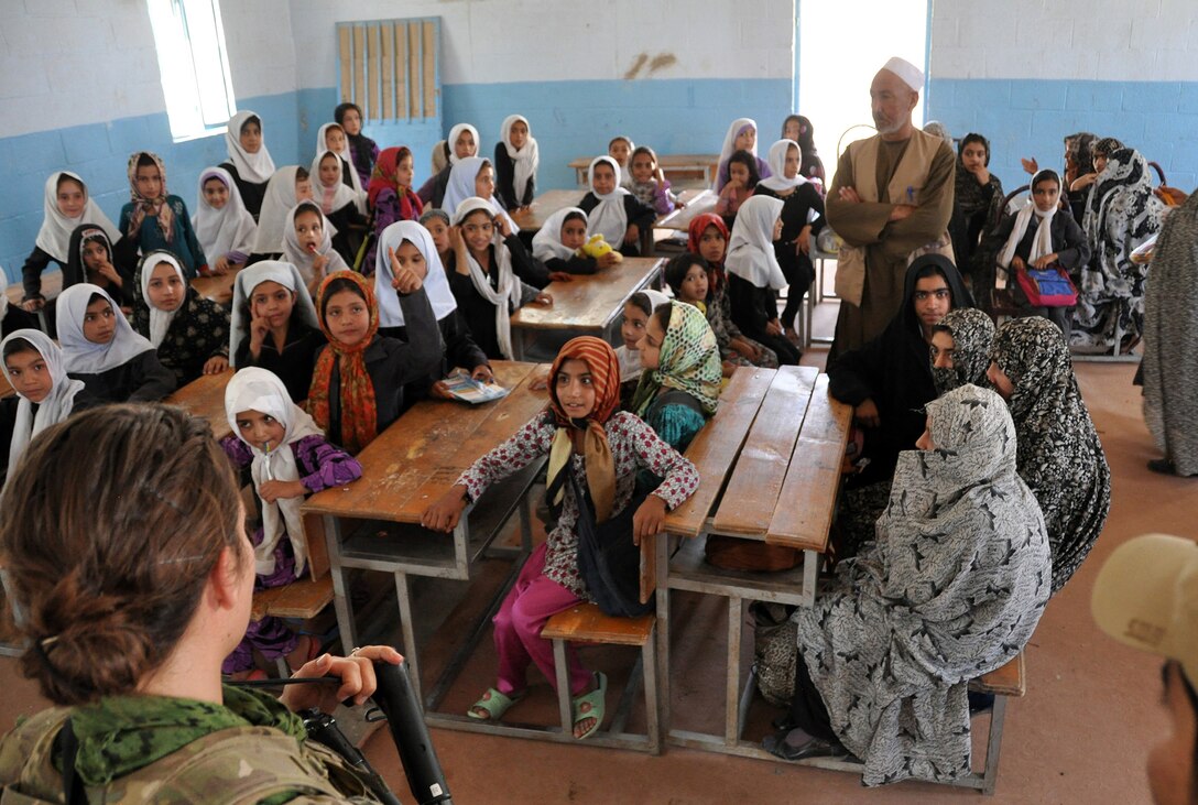 U.S. Army Capt. Jennifer Leathers, bottom left, addresses Afghan orphans during a mission to deliver toys, books and health supplies to children at the Farah Orphanage in Farah City, Afghanistan, Sept. 26, 2013. Troops also participated in a key leader engagement and inspected a completed solar power project. Leathers is assigned to the Provincial Reconstruction Team Farah.