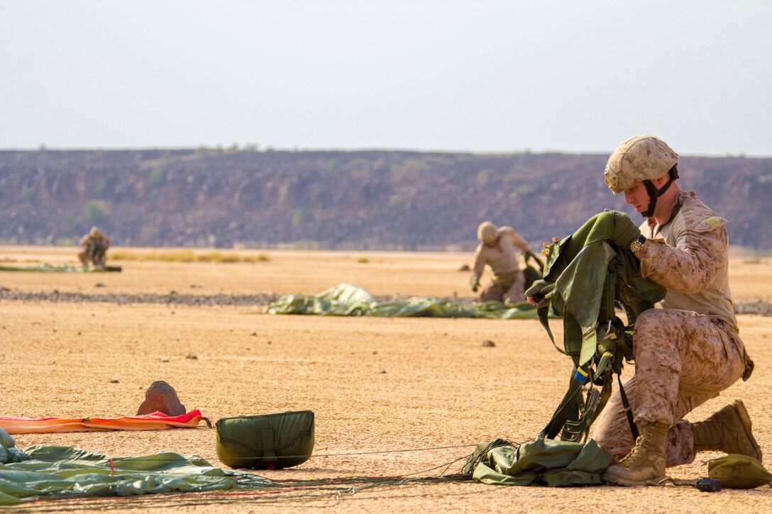 U.S. Marines assigned to Reconnaissance Platoon, Battalion Landing Team (BLT) 3/2, 26th Marine Expeditionary Unit (MEU), pack their parachutes after conducting static line parachute operations over Djibouti, Africa, Sept. 23, 2013. The 26th MEU is a Marine Air-Ground Task Force forward-deployed to the U.S. 5th and 6th Fleet areas of responsibility aboard the Kearsarge Amphibious Ready Group serving as a sea-based, expeditionary crisis response force capable of conducting amphibious operations across the full range of military operations. (U.S. Marine Corps photo by Cpl. Kyle N. Runnels/Released)