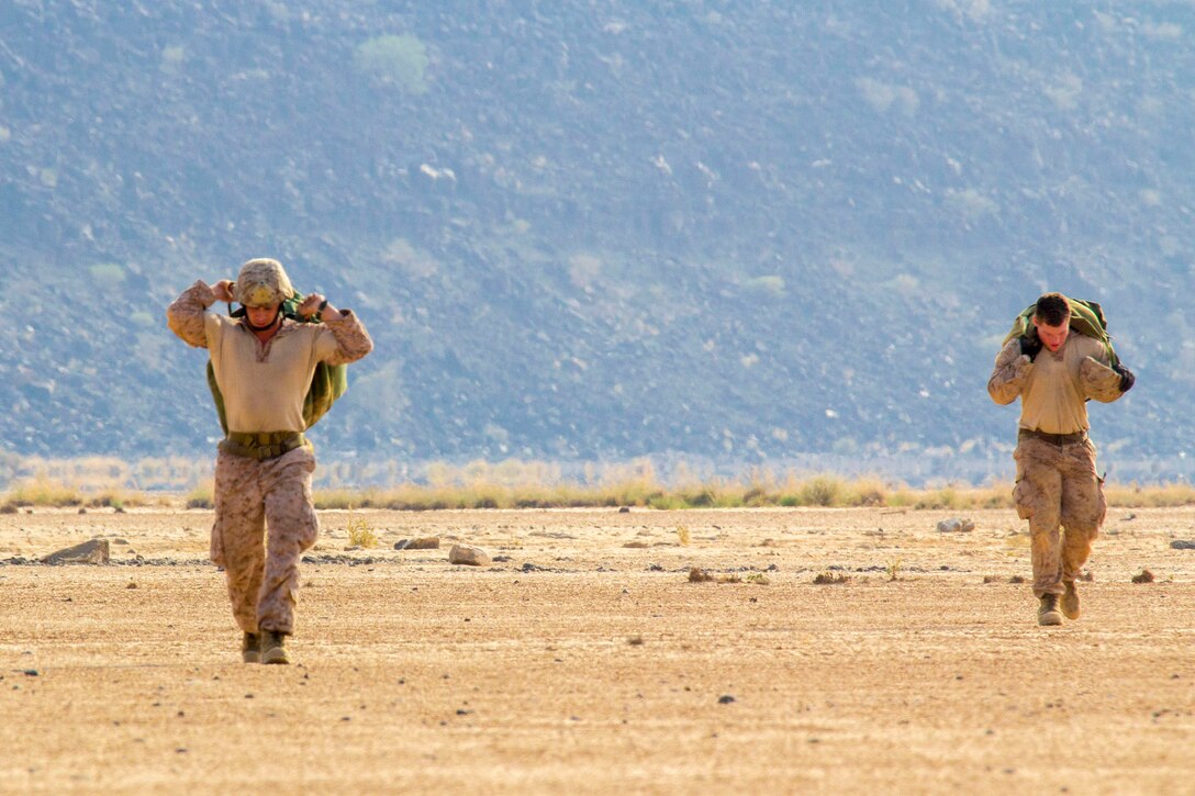 U.S. Marines assigned to Reconnaissance Platoon, Battalion Landing Team (BLT) 3/2, 26th Marine Expeditionary Unit (MEU), carry their parachutes after conducting static line parachute operations over Djibouti, Africa, Sept. 23, 2013. The 26th MEU is a Marine Air-Ground Task Force forward-deployed to the U.S. 5th and 6th Fleet areas of responsibility aboard the Kearsarge Amphibious Ready Group serving as a sea-based, expeditionary crisis response force capable of conducting amphibious operations across the full range of military operations. (U.S. Marine Corps photo by Cpl. Kyle N. Runnels/Released)