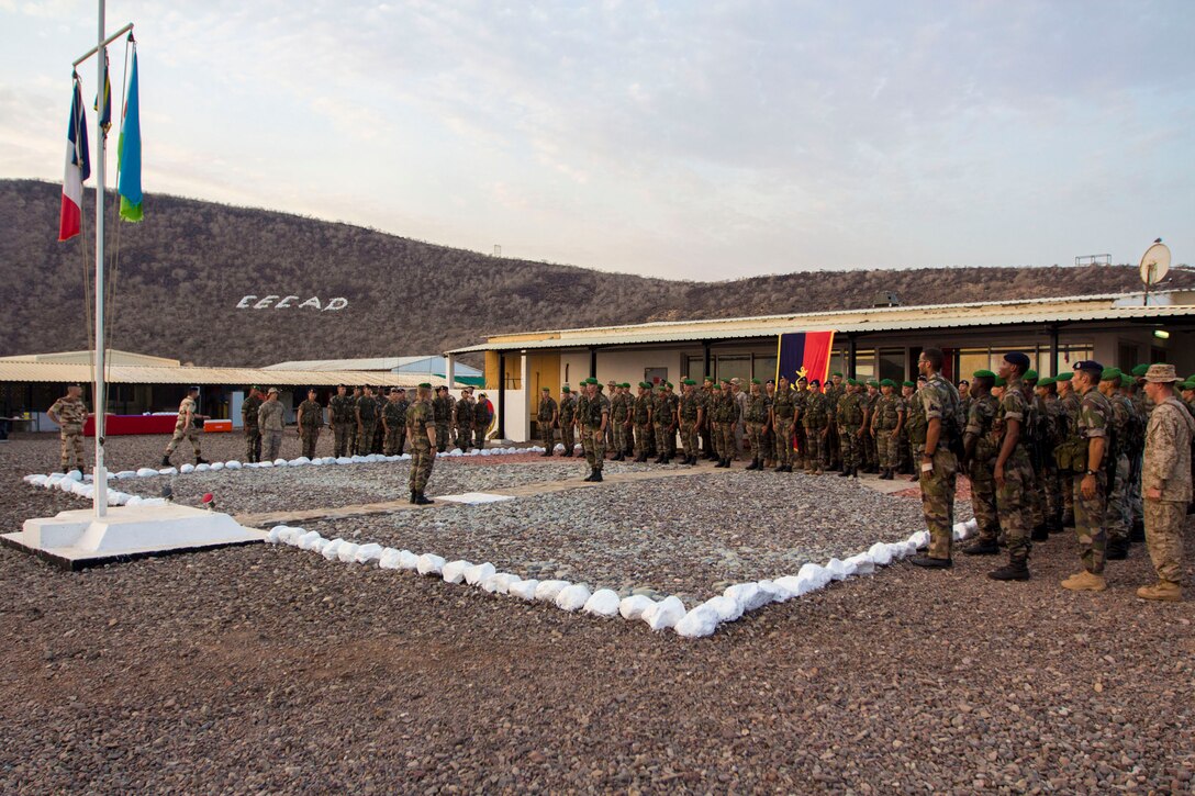 U.S. Marines assigned to the 26th Marine Expeditionary Unit (MEU), stand with French forces in a formation during a ceremony to commemorate their accomplishment of completing a 10-day desert survival course in the 5th Fleet area of responsibility, Sept. 25, 2013. The 26th MEU is a Marine Air-Ground Task Force forward-deployed to the U.S. 5th and 6th Fleet areas of responsibility aboard the Kearsarge Amphibious Ready Group serving as a sea-based, expeditionary crisis response force capable of conducting amphibious operations across the full range of military operations. (U.S. Marine Corps photo by Cpl. Kyle N. Runnels/Released)