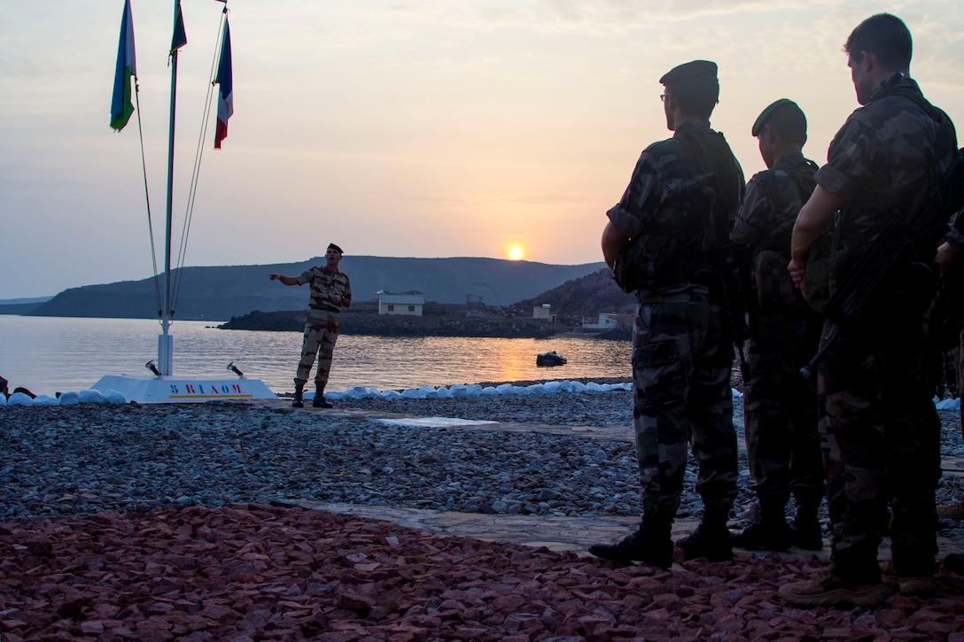 U.S. Marines assigned to the 26th Marine Expeditionary Unit (MEU), stand with French forces in a formation during a ceremony to commemorate their accomplishment of completing a 10-day desert survival course in the 5th Fleet area of responsibility, Sept. 25, 2013. The 26th MEU is a Marine Air-Ground Task Force forward-deployed to the U.S. 5th and 6th Fleet areas of responsibility aboard the Kearsarge Amphibious Ready Group serving as a sea-based, expeditionary crisis response force capable of conducting amphibious operations across the full range of military operations. (U.S. Marine Corps photo by Cpl. Kyle N. Runnels/Released)