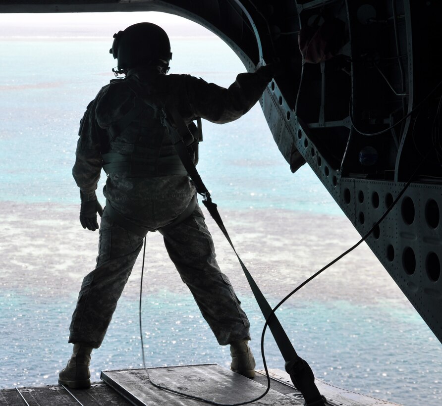 A crewchief takes in the view of a corral reef off the coast of Honduras from the ramp of a CH-47 Chinook helicopter, Sept. 28, 2013. The Chinook was transporting members of Joint Task Force-Bravo's Central America Survey and Assessment team back to Soto Cano Air Base following an exercise operation in Belize. (U.S. Air Force photo by Capt. Zach Anderson)