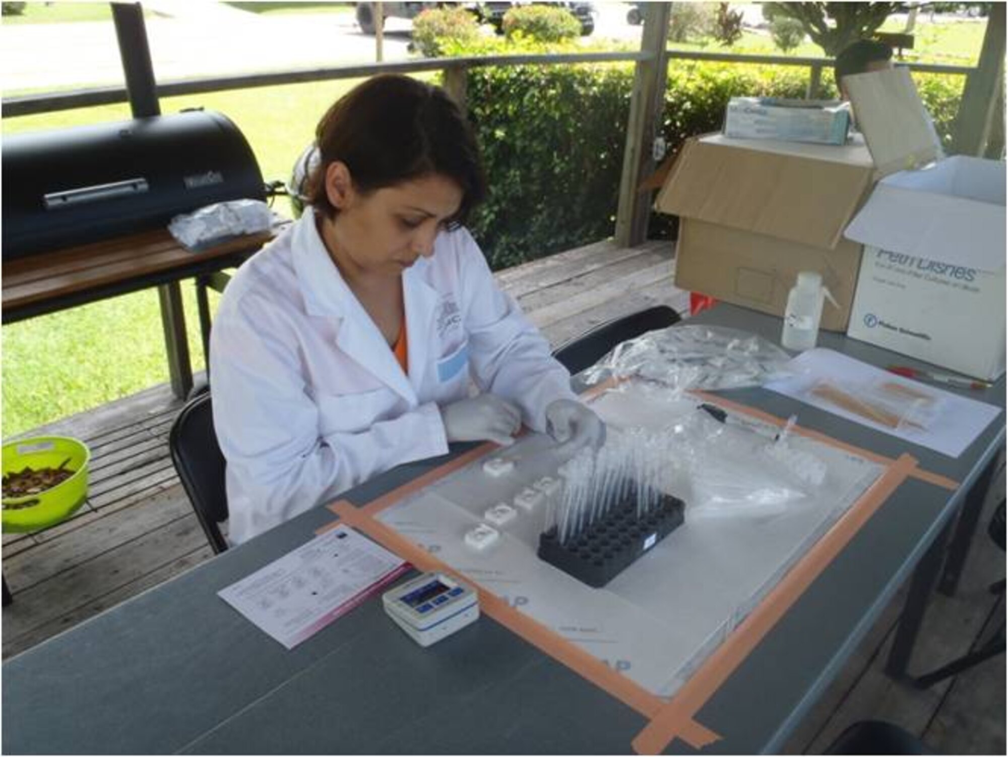 Azwneth Sexauer from U.S. Army Public Health Command South Region places a sample into the cartridge to test for Giardia and Cryptosporidium, during her visit here, Sep 25, 2013.  These tests are part of a study to see if certain approved FDA tests could be used in extreme environments. (Photo by U.S. Army Sgt. Courtney Kreft)
