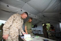 Brig. Gen. Niel E. Nelson, left, reviews operational documents with Sgt. Damon R. Wheeler Sept. 18 at Landing Zone Dodo in the Central Training Area. Nelson is the commanding general of 3rd MLG, and Wheeler is an ammunition technician with Ammunition Co.


