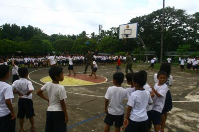 Petty Officers 2nd Class Neil C. Domingo, left, Kahealani W. Aipia play basketball with students from Taysan Elementary School September 23 at the school in Legazpi City, Albay, Republic of the Philippines, as part of Amphibious Landing Exercise 2014. The civil-military component of PHIBLEX 14 promotes engineer and medical operational readiness while providing services to areas where there is an identified need for engineering improvements and medical care. Aipia and Domingo are hospital corpsmen with 3rd Medical Battalion, 3rd Marine Logistics Group, III Marine Expeditionary Force.