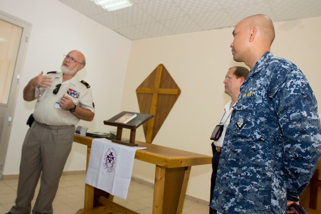 A French military chaplain explains his job as U.S. Navy Lt. Cmdr. Ulysses L. Ubalde, USS Kearsarge (LHD 3) chaplain, listens, aboard Camp Lemonnier, Djibouti, Sept. 27, 2013. The 26th Marine Expeditionary Unit is a Marine Air-Ground Task Force forward-deployed to the U.S. 5th and 6th Fleet areas of responsibility aboard the Kearsarge Amphibious Ready Group serving as a sea-based, expeditionary crisis response force capable of conducting amphibious operations across the full range of military operations. (U.S. Marine Corps photo by Cpl. Kyle N. Runnels/Released)