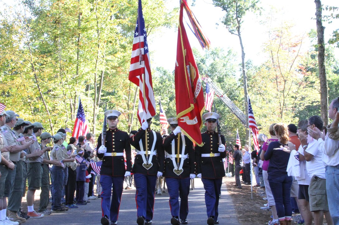 Marines from the 1st Marine Corps District present the colors during the homecoming celebration Sept. 28.  Hundreds of onlookers lined the Caron’s new driveway welcoming Sgt. Greg Caron, a Marine veteran, and his wife, Nina, into their new home.  (U.S. Marine Corps photo by Pfc. Brandon Thomas).