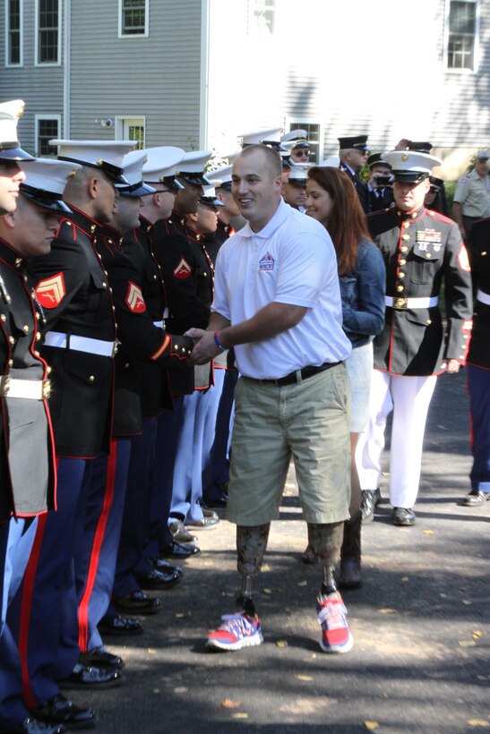Sgt. Greg Caron, a Marine Veteran, shakes hands with Marines from Fox Company, 2nd Battalion, 25th Marine Regiment, his previous unit, Sept. 28 during his welcome home celebration.  Caron is one of 17, 9/11 first responders and combat veterans to receive a home this year from the organization Building Homes for Heroes.  


