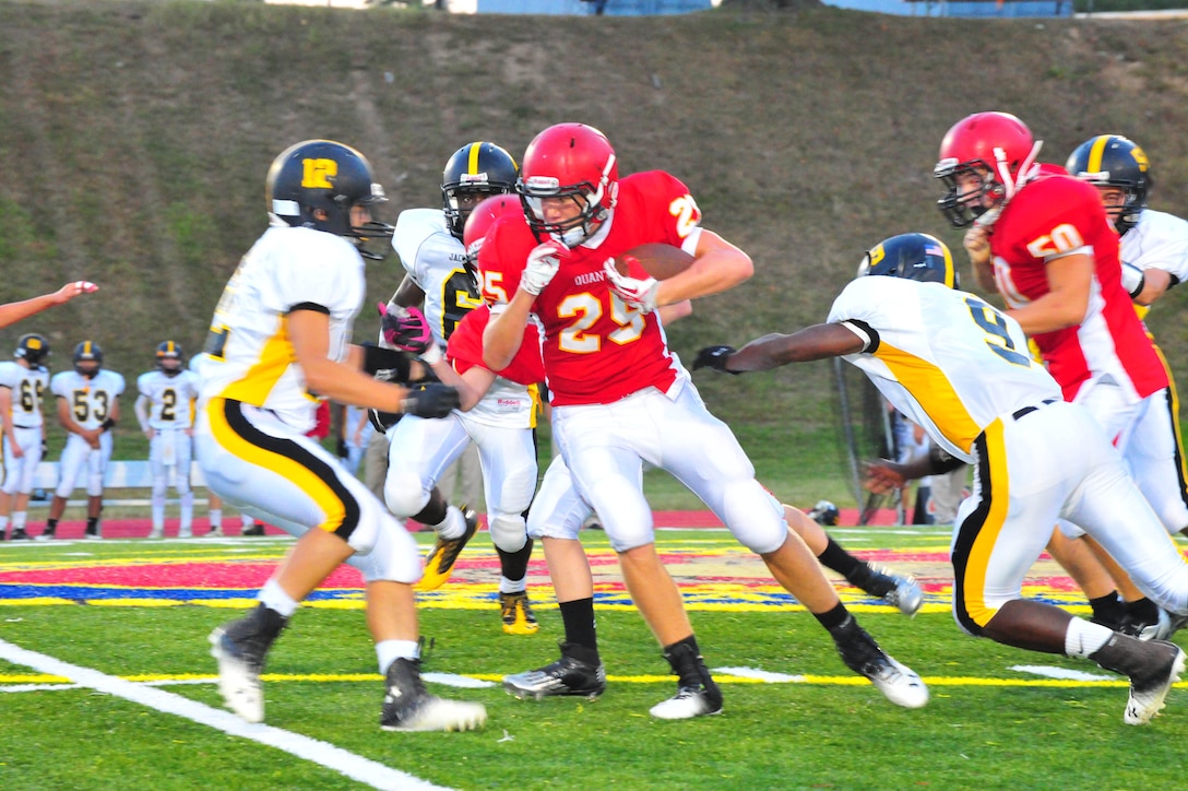 Codie, sophomore player, tries to avoid a tackle during a game between the Quantico Middle/High School Warriors and the Randolph-Macon Academy Yellowjackets from Front Royal, Va., at Butler Stadium on Sept. 23, 2013. The Warriors lost their fifth game of the season 40-7. (Marine Corps photo by Lance Cpl. Samuel Ellis/Released)