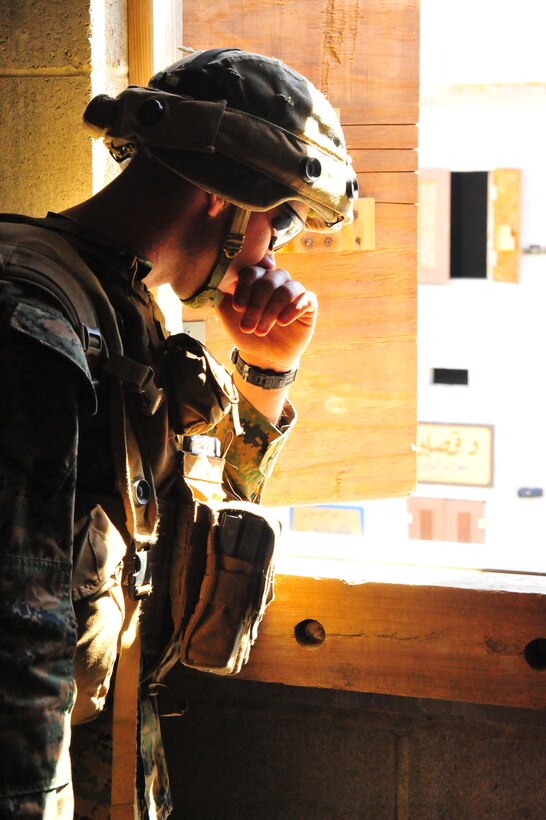 A Marine looks out a window during a training exercise aboard Marine Corps Base Quantico on Sept. 25, 2013. Charlie Co. participated in an urban combat training exercise as one of the last field exercises they will conduct before their graduation from The Basic School on Oct. 30, 2013. (U.S. Marine Corps photo by Lance Cpl. Samuel Ellis/ Released)