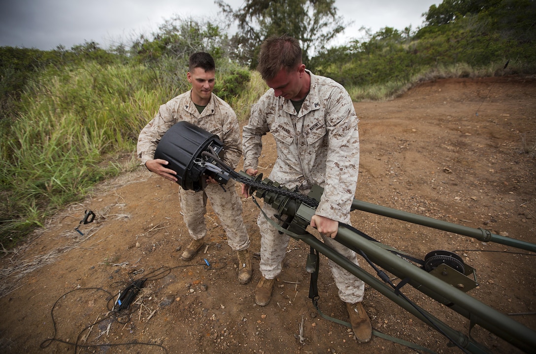 Cpl. Kyle Ross, a 27-year-old linguist with Signals Support Team 1, Alpha Company, 3rd Radio Battalion, and native of Des Moines, Iowa, (left), pulls the top portion of an antenna off as he works to disassemble it with support provided by his partner, Cpl. James Hearne, a 24-year-old who is the team leader of SST1, Alpha Co., 3rd Radio Battalion, and native of San Antonio, Sept. 26, 2013. (U.S. Marine Corps photo by Lance Cpl. Matthew Bragg)