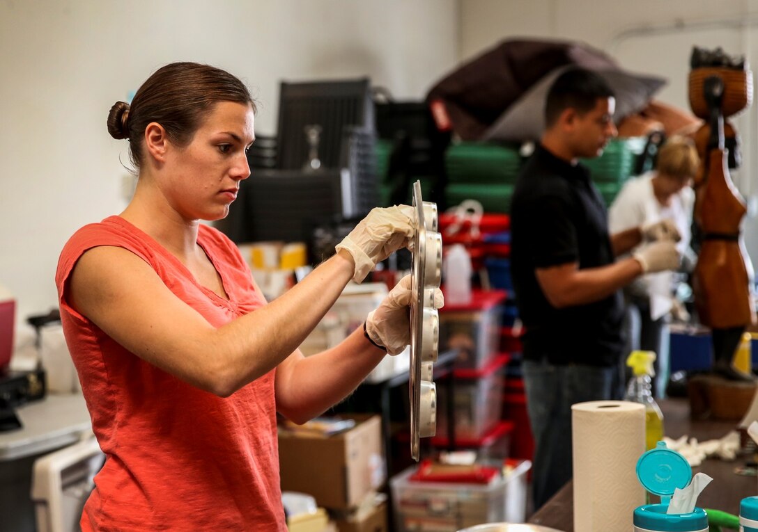 Captain Johanna Ciezczak, force protection officer, 15th Marine Expeditionary Unit, wipes down a baking tray during a volunteer event at The Angel's Depot in Vista, Calif., Sept. 26. All donations go to improving the quality of life for senior citizens. Ciezczak, 27, is from Chicago. (U.S. Marine Corps photo by Cpl. Emmanuel Ramos/Released)