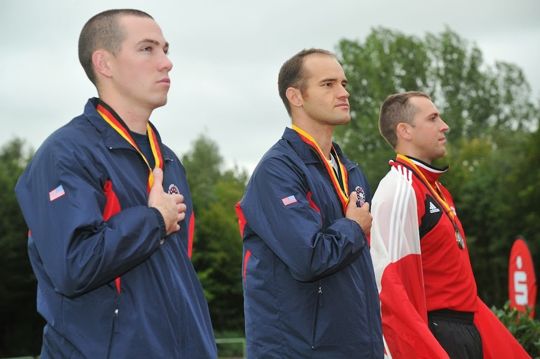 Army Sergeants Robert Brown (center) and Ryan McIntosh (left) receive their 2nd medal after competing in the 200m Class-A (Below Knee Amputee) race of the 2013 CISM Open Integrated/Para Track and Field Championship in Warendorf, Germany 9-16 September.  Both Brown and McIntosh are with the Armys World Class Athlete Program training for the 2016 Paralympic Games.  Both Brown and McIntosh won Gold and Silver respectively in both the 100m and 200m competitions.