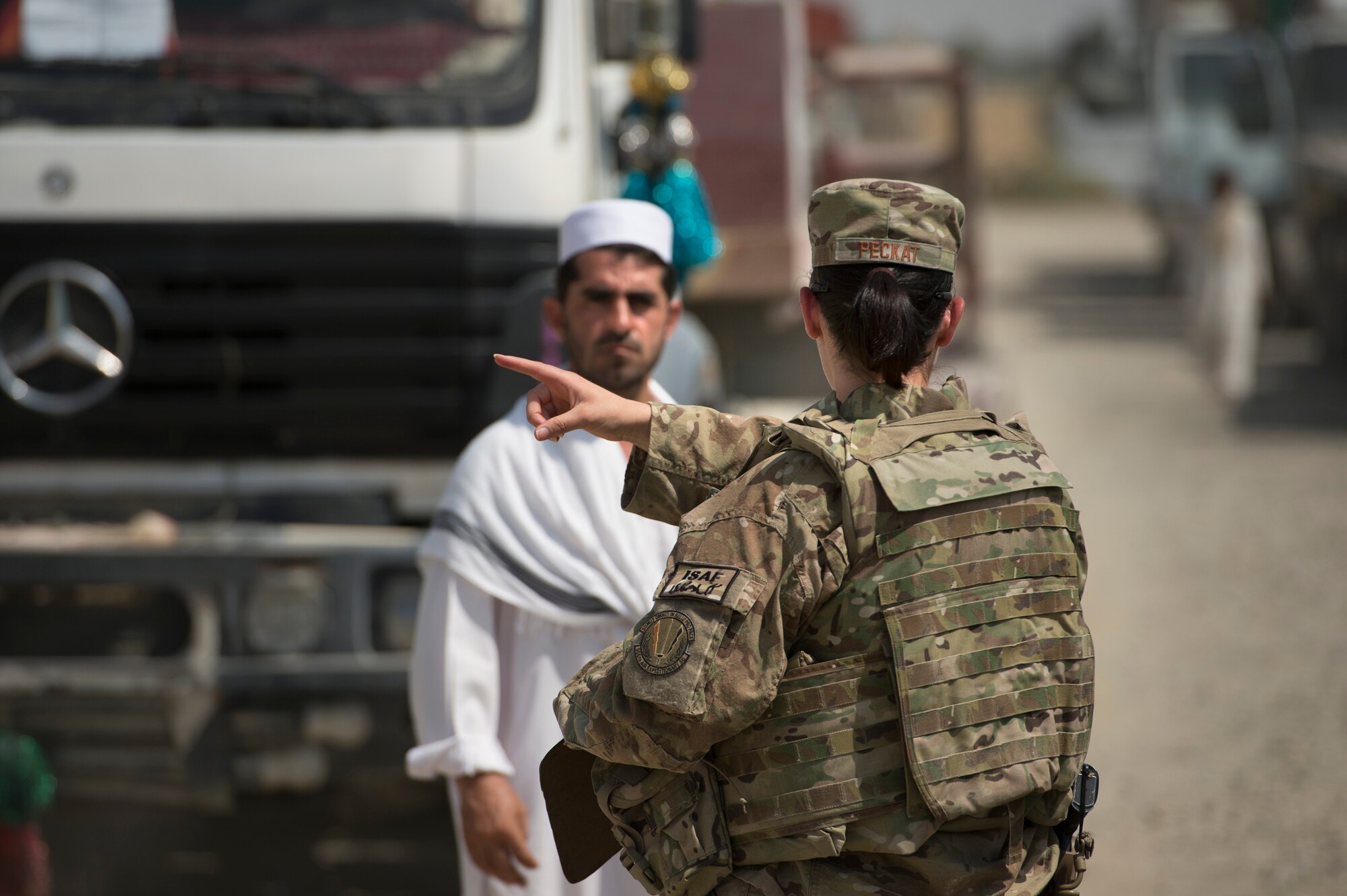 Tech. Sgt. Christina Peckat, 19th Movement Control Team surface movement Airman, coordinates trucker traffic with Abdul Basir, a parking attendant, at Forward Operating Base Salerno, Khost province, Afghanistan, Sept. 22, 2013. The 19th MCT, a small squadron of Air Force surface movement controllers and aerial porters, have the herculean task of overseeing the vast majority of retrograde operations at FOB Salerno. Peckat, a Denver, Colo. native, is deployed from RAF Mildenhall, England.
