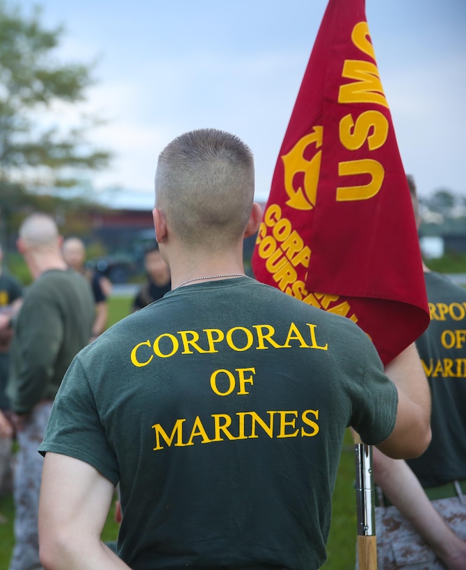 Corporal Trevor L. Jones, an amphibious assault vehicle crewman with 2nd Assault Amphibian Battalion, 2nd Marine Division, holds the guide-on after the corporal’s course motivational hike Sept. 26, 2013 aboard Marine Corps Base Camp Lejeune. A total of 54 corporals started the course and graduated Sept. 27, 2013. 