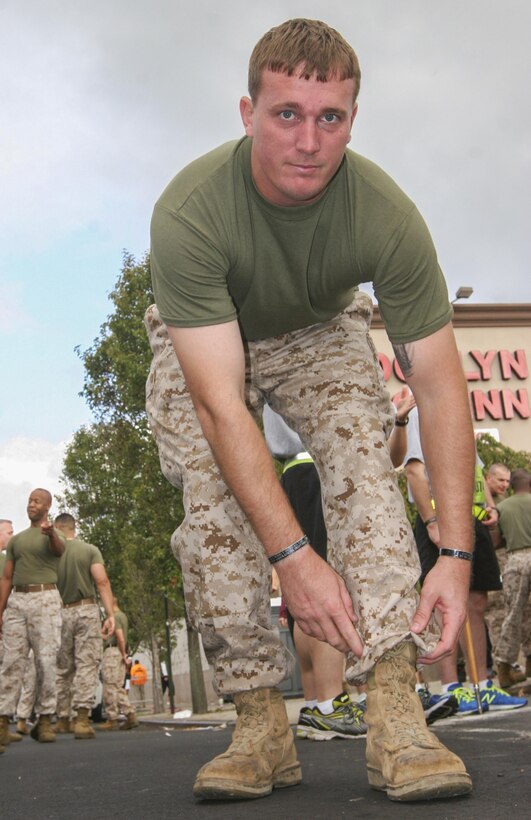 Sgt. Dakota Meyer, a Medal of Honor recipient, poses for a photo Sept. 29 showing the boots he wore when he performed the actions that led him to recieve the medal.  Meyer stated that this was the first time he had worn his boots since those actions took place.  Tunnel to Towers, a 5-kilometer run, is held annually in honor of firefighter Stephen Siller.  Siller, who ran to the World Trade Center through the Battery Tunnel with all his gear on during the attacks on 9/11, ultimately lost his life during his attempt to save others.  (U.S. Marine Corps photo by Capt. Timothy Irish).