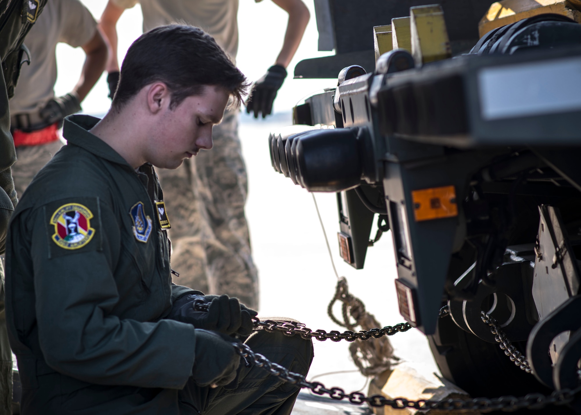 Airman 1st Class Steven Spurlock, 36th Airlift Squadron loadmaster, attaches chains to a Next Generation Small Loader before loading it aboard a C-130 Hercules during a training session at Yokota Air Base, Japan, Sept. 30, 2013. 36 AS Airmen worked with riggers from the 374th Logistics Readiness Squadron to practice loading heavy equipment aboard their aircraft. (U.S. Air Force photo by Captain Raymond P. Geoffroy/Released)