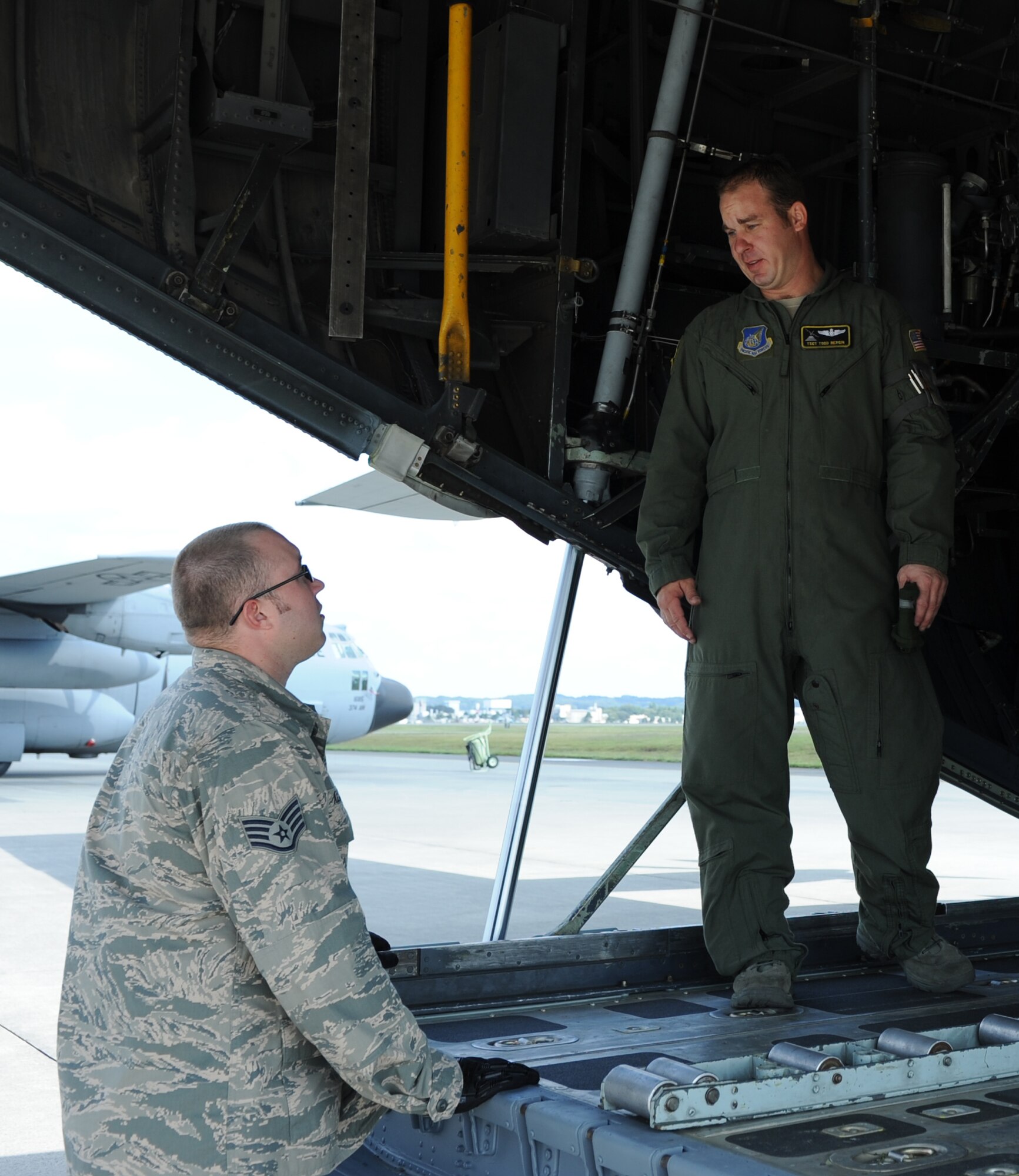 Left to right, Staff Sgt. Macer Allen, 374th Logistics Readiness Squadron, and Tech. Sgt. Todd Bergin, 36th Airlift Squadron, discuss the training plan for loading a Next Generation Small Loader onto a C-130 Hercules at Yokota Air Base, Japan, Sept. 30, 2013. The 36 AS and 374 LRS worked together to conduct training on loading heavy equipment onto a C-130. (U.S. Air Force photo by Senior Airman Desiree Economides/Released)