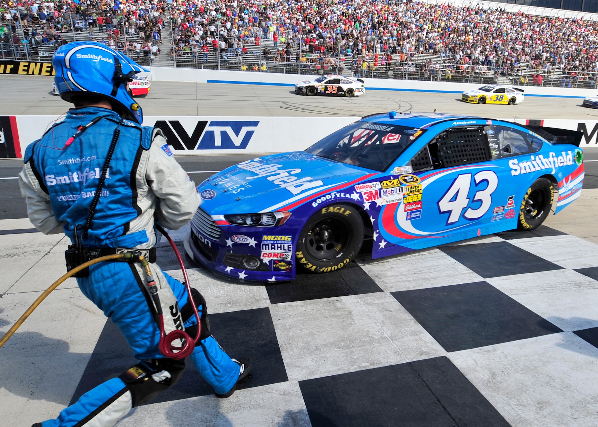 A pit crew member runs out as Aric Almirola, driver of the No. 43 Smithfield/U.S. Air Force Ford pulls into his pit stall during the AAA 400 Sept. 29, 2013, at Dover International Speedway in Dover, Del. Almirola was pitting under a caution for debris on the track. (U.S. Air Force photo/Tech. Sgt. Chuck Walker)