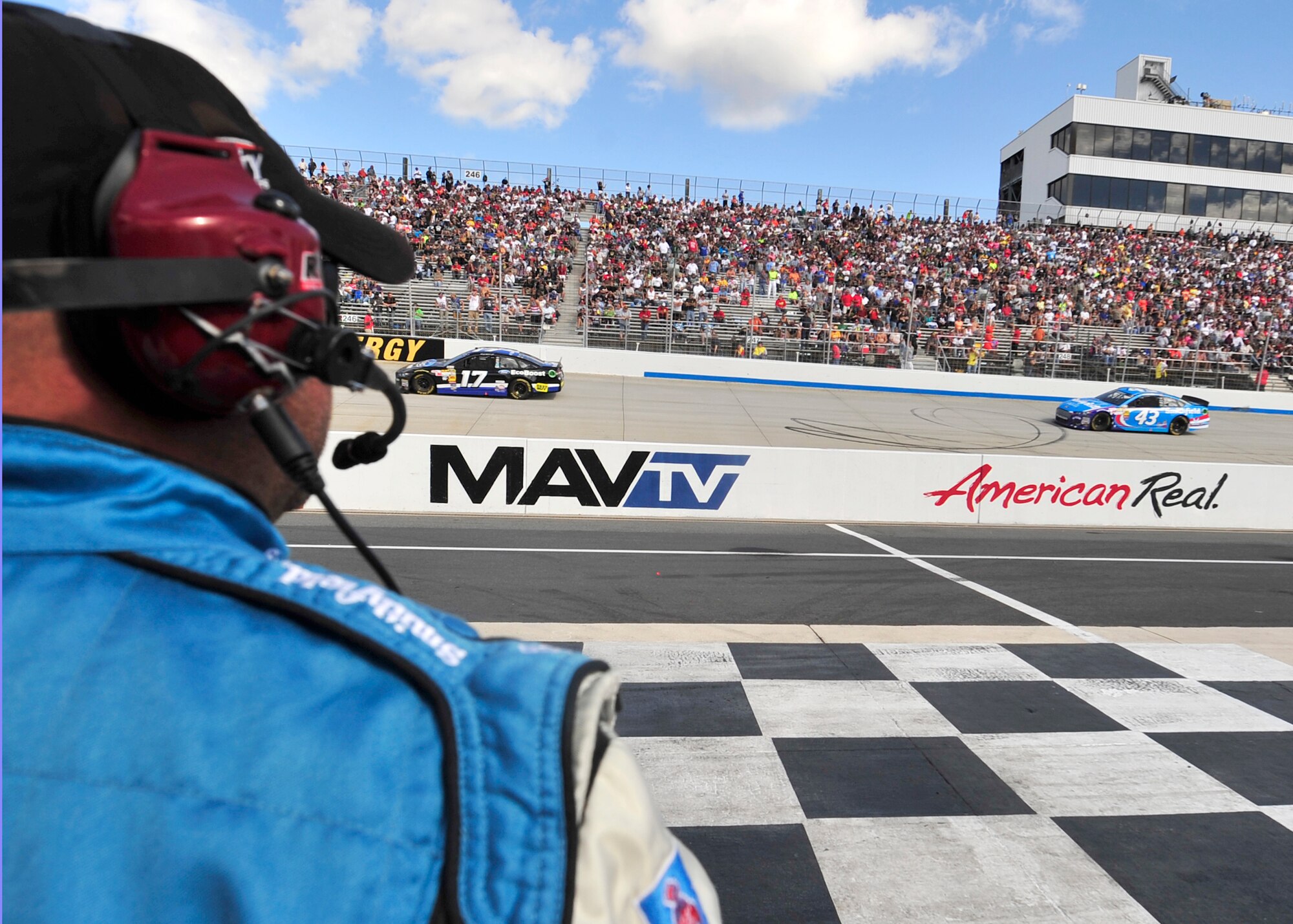 A pit-crew member looks on as Aric Almirola, driver of the No. 43 Smithfield/U.S. Air Force Ford, races down the front stretch into turn one during the AAA 400 Sept. 29, 2013, at Dover International Speedway in Dover, Del. Almirola started the race from the fifth position at finished in 22nd place. (U.S. Air Force photo/Tech. Sgt. Chuck Walker)