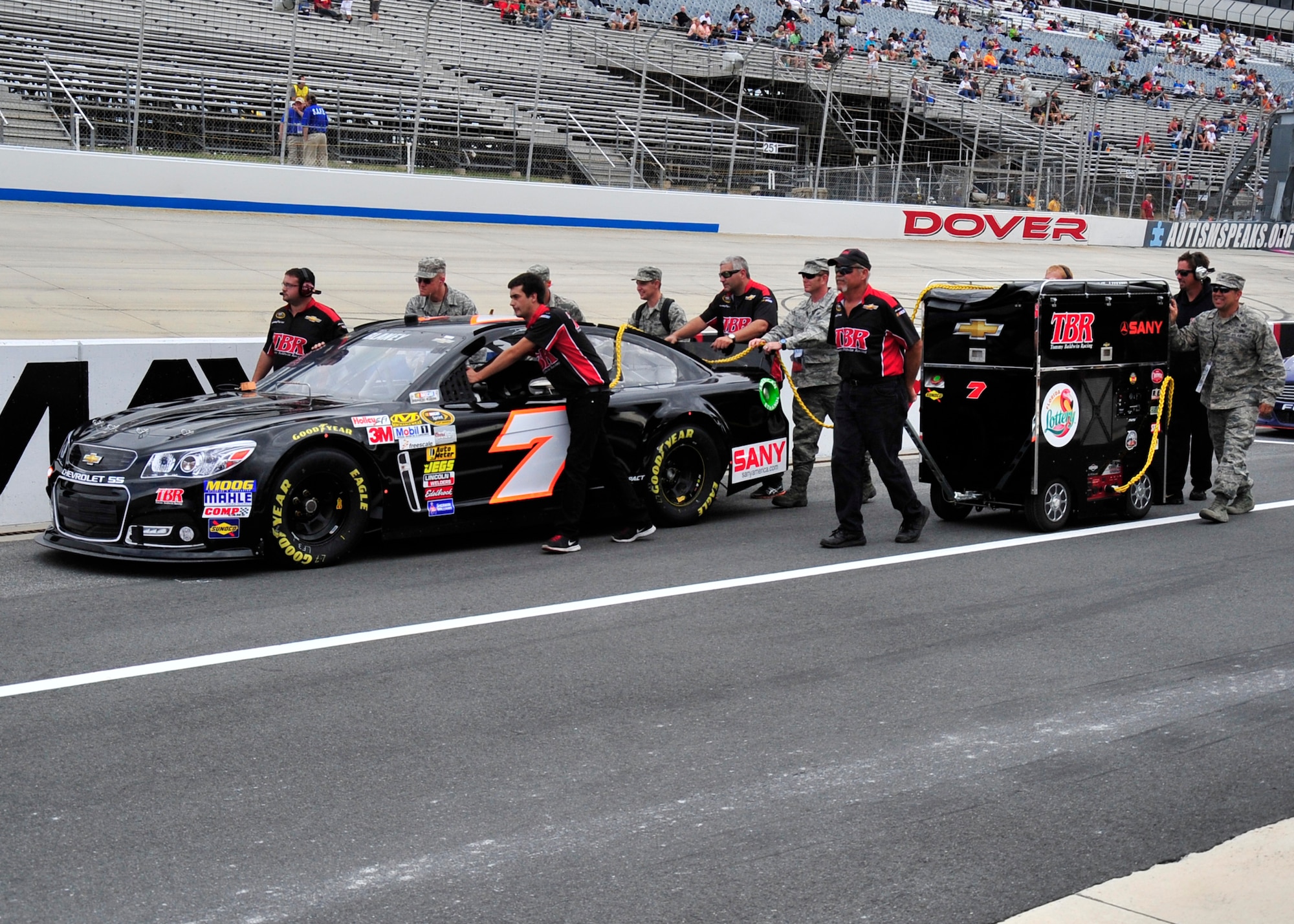 Members of Dave Blaney’s pit crew and honorary pit crew members from Dover Air Force Base push Blaney’s No. 7 Tommy Baldwin Racing Chevy down pit road before qualifying for the AAA 400 Sept. 27, 2013, at Dover International Speedway, Dover, Del. The honorary pit crew members got an inside look at racing, spent time with the drivers and teams and helped with pit stops. (U.S. Air Force photo/Tech. Sgt. Chuck Walker)