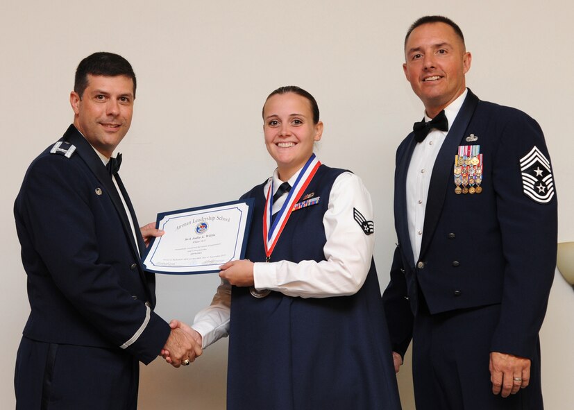 Senior Airman Jodie Willis, 2nd Bomb Wing, receives an Airman Leadership School graduation certificate from Col. Andrew Gebara, 2nd Bomb Wing commander, on Barksdale Air Force Base, La., Sept. 26, 2013. (U.S. Air Force photo)