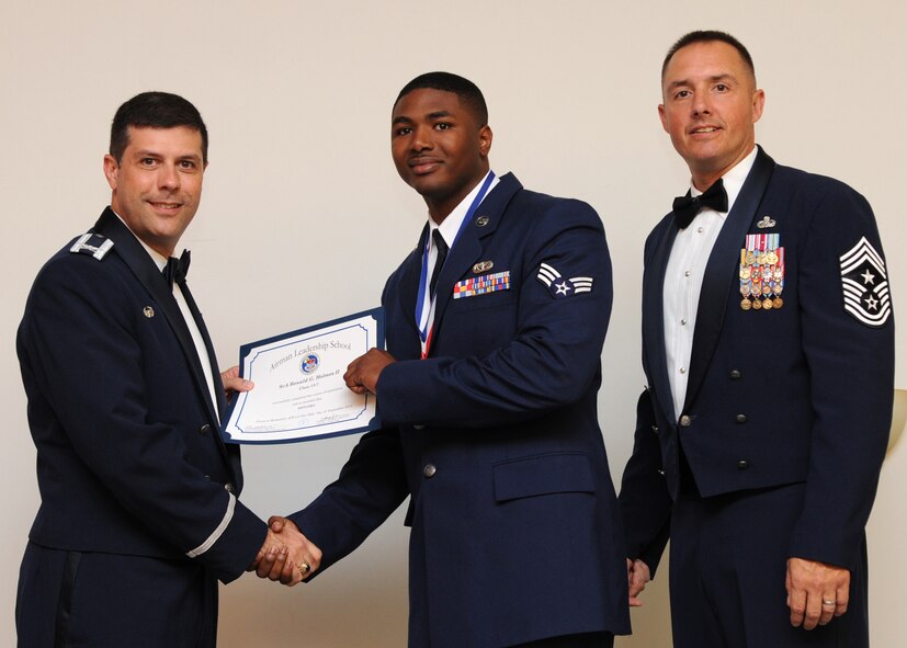 Senior Airman Ronald Holmes II, 2nd Force Support Squadron, receives an Airman Leadership School graduation certificate from Col. Andrew Gebara, 2nd Bomb Wing commander, on Barksdale Air Force Base, La., Sept. 26, 2013. (U.S. Air Force photo)
