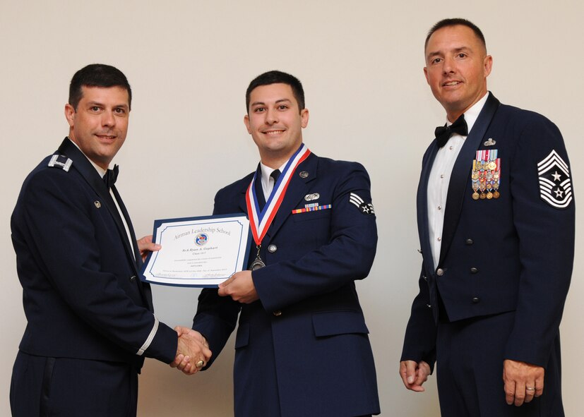 Senior Airman Ryan Gephart, 2nd Communications Squadron, receives an Airman Leadership School graduation certificate from Col. Andrew Gebara, 2nd Bomb Wing commander, on Barksdale Air Force Base, La., Sept. 26, 2013. (U.S. Air Force photo)