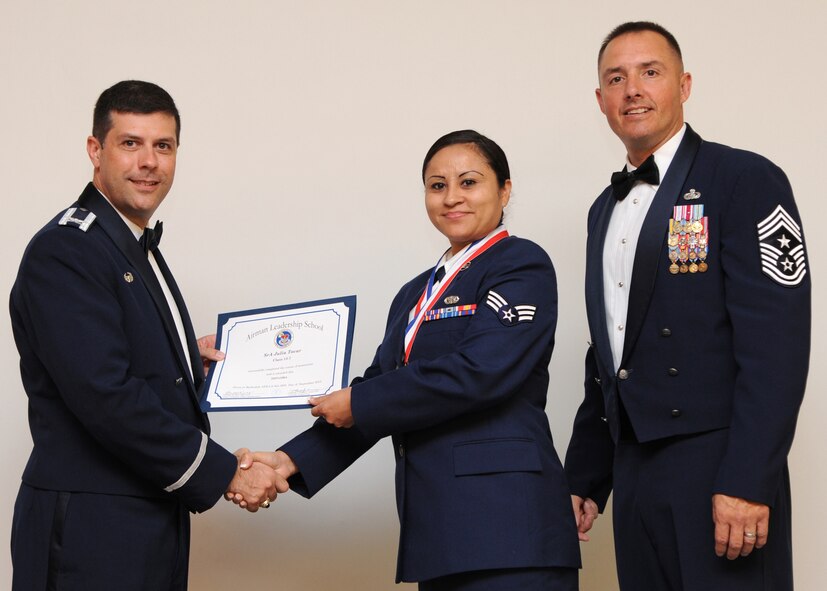 Senior Airman Julia Tovar, 433rd Maintenance Squadron, Lackland Air Force Base, Texas, receives an Airman Leadership School graduation certificate from Col. Andrew Gebara, 2nd Bomb Wing commander, on Barksdale AFB, La., Sept. 26, 2013. (U.S. Air Force photo)